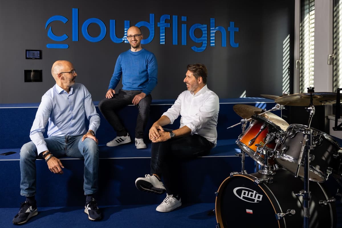 Managing Directors sitting in the Vienna office smiling at each other