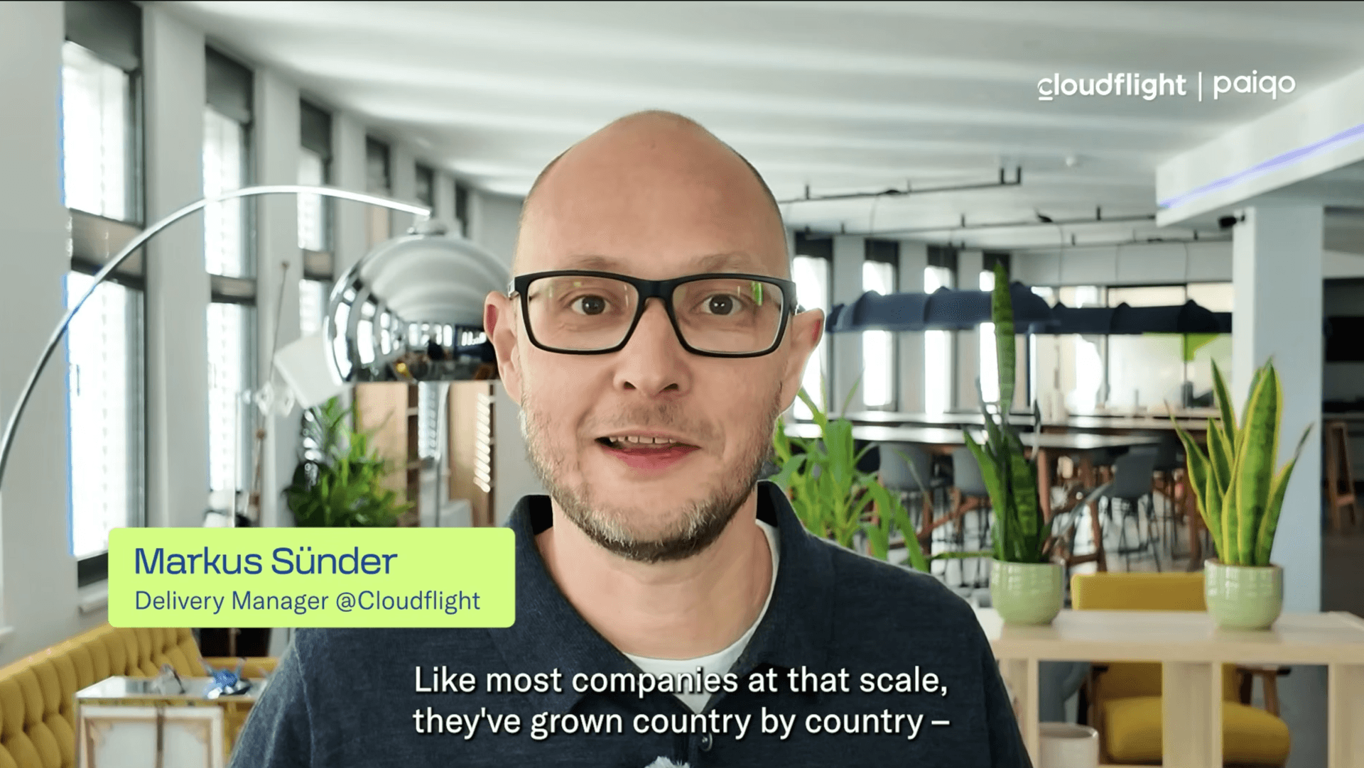 Markus Sünder, Delivery Manager at Cloudflight, speaks in an office setting about SAP S/4HANA digital transformation, with subtitles displayed at the bottom of the screen.
