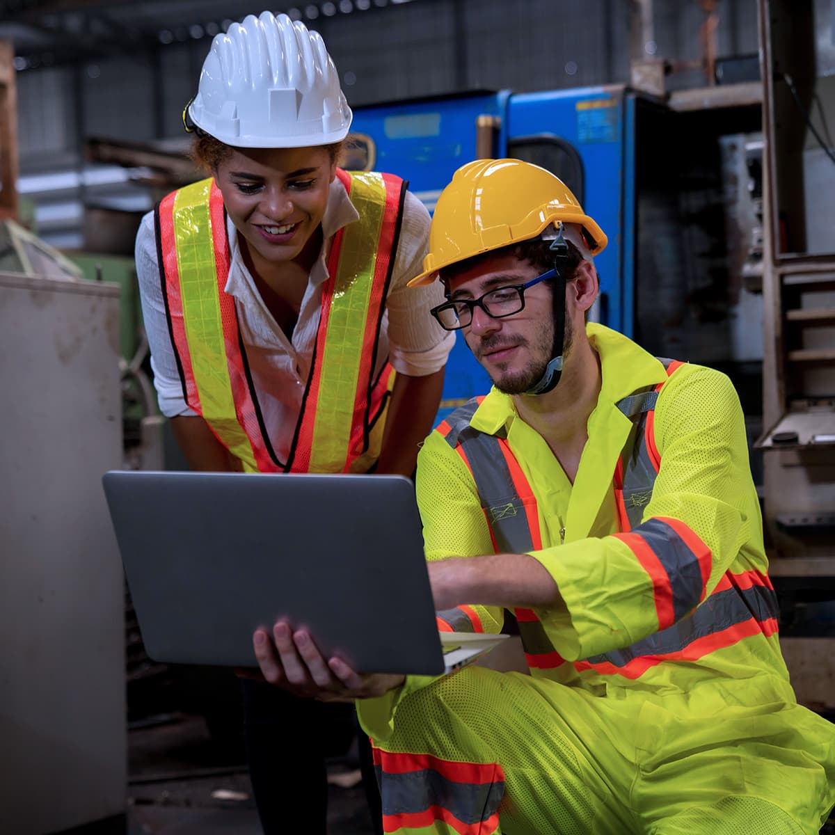 Professional engineers and technicians are inspecting machine operations via a laptop computer.