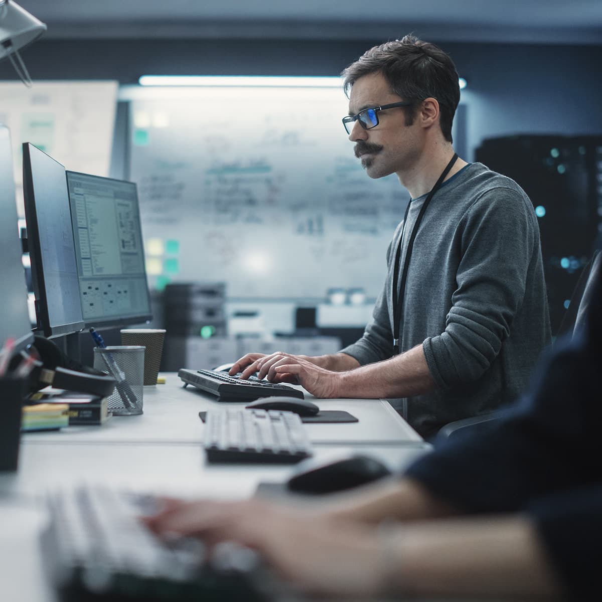 Portrait of a Thoughtful Engineer Working on Desktop Computer in a Technological Office Environment