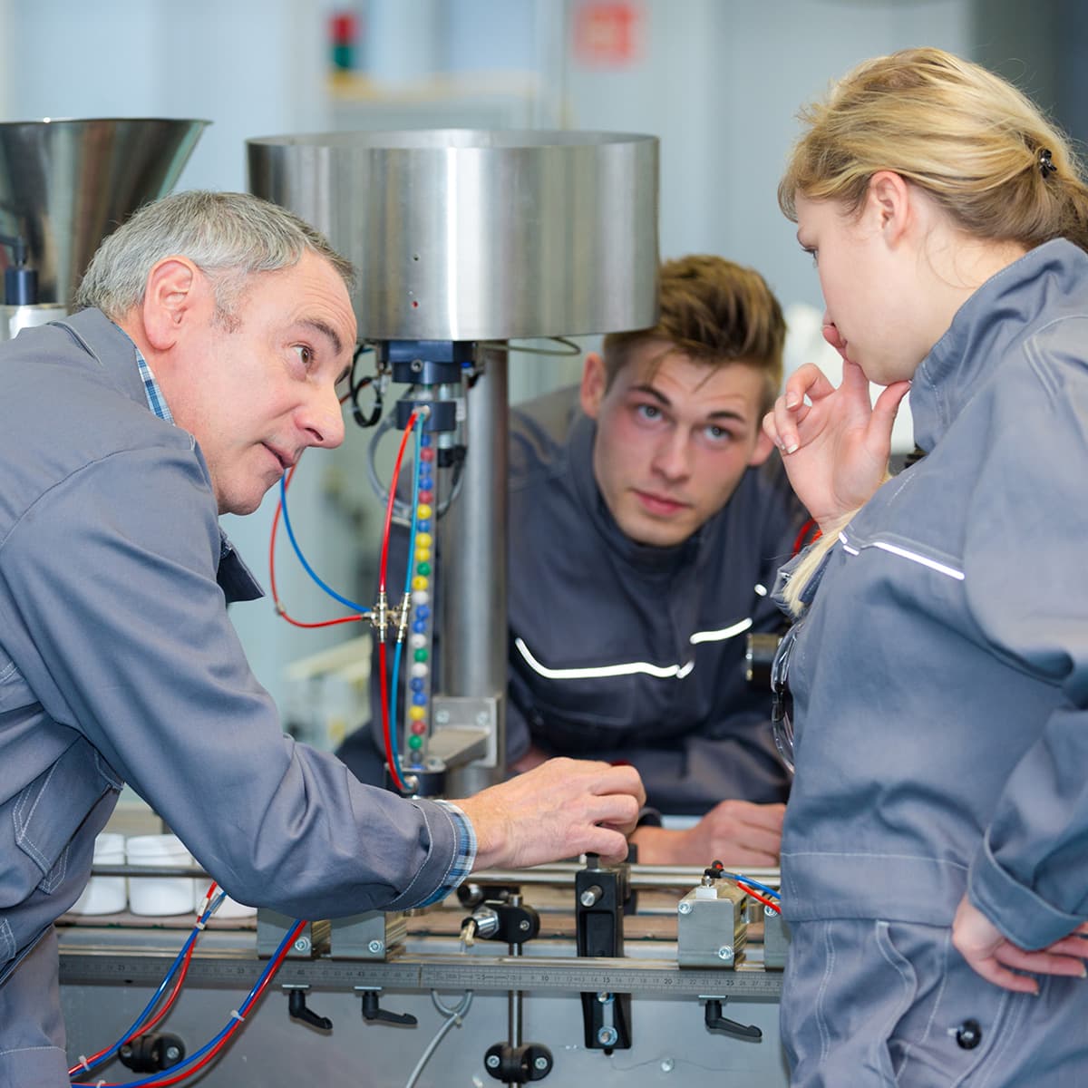 team of apprentices operanting a machine